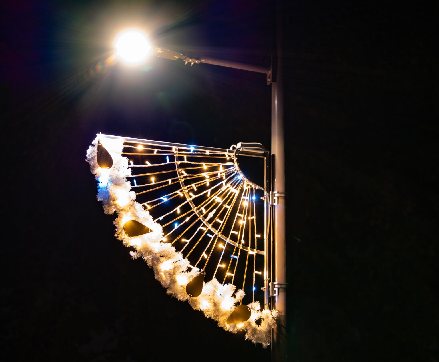 Gros plan sur la décoration lumineuse et lanterne du lampadaire solaire autonome EverGen allumé de nuit